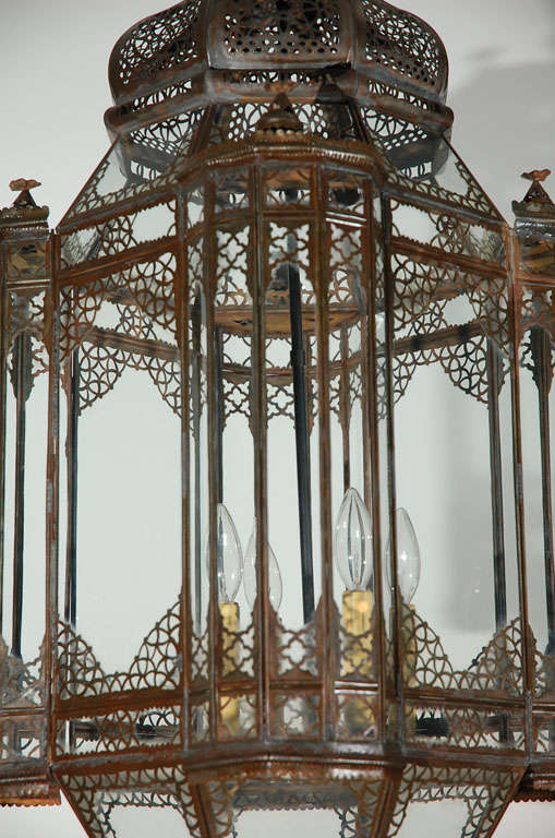 Very nice vintage handcrafted clear glass Moroccan lantern with intricate Moorish filigree designs on bronze finish metal.
This Moroccan chandelier is rewired with 3 lights, 12 feet chains and canopy included.
Indoor use only.

  
