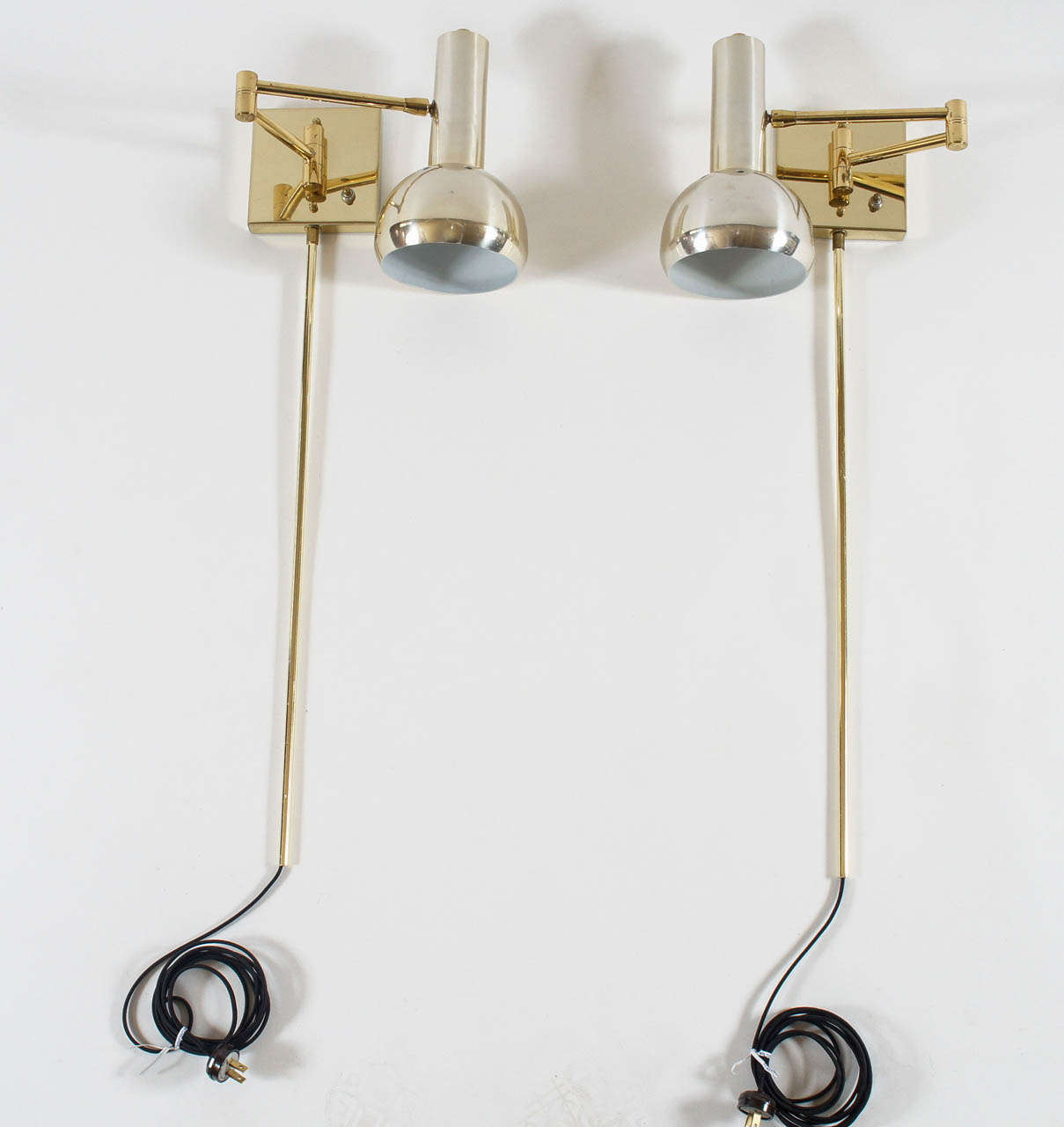 Chic vintage circa 1970 two-tone brass swing-arm wall mount reading lamps with shades having white enameled interiors and circular perforations at top.  Rewired for North American use.  Shades measure 10