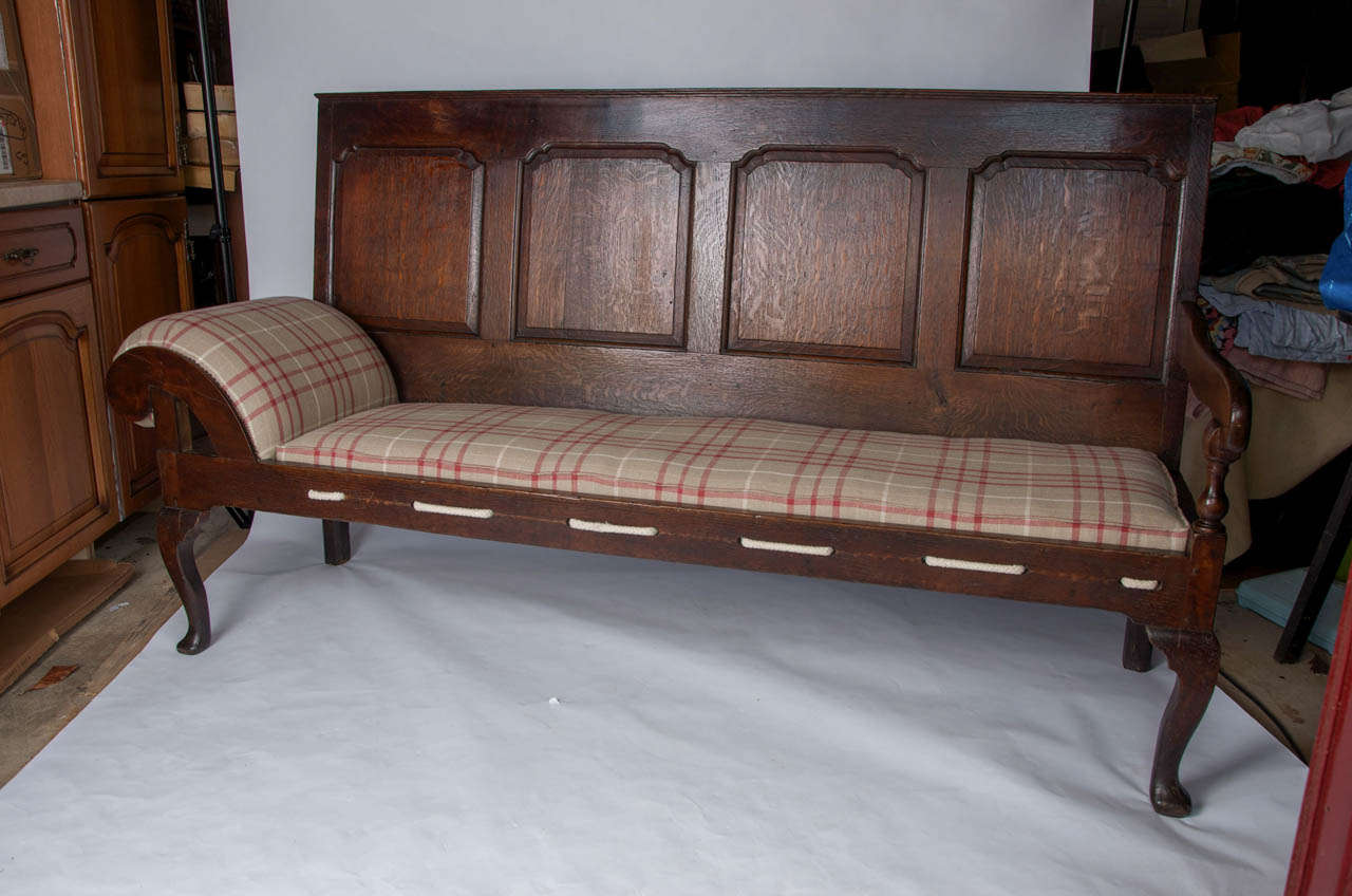 This is a superb and rare example of an English daybed or settle from the Queen Anne period, made of English Oak, Circa 1710.

It has four fielded panels, the end sides extending down to form the rear legs which are square in section with inner