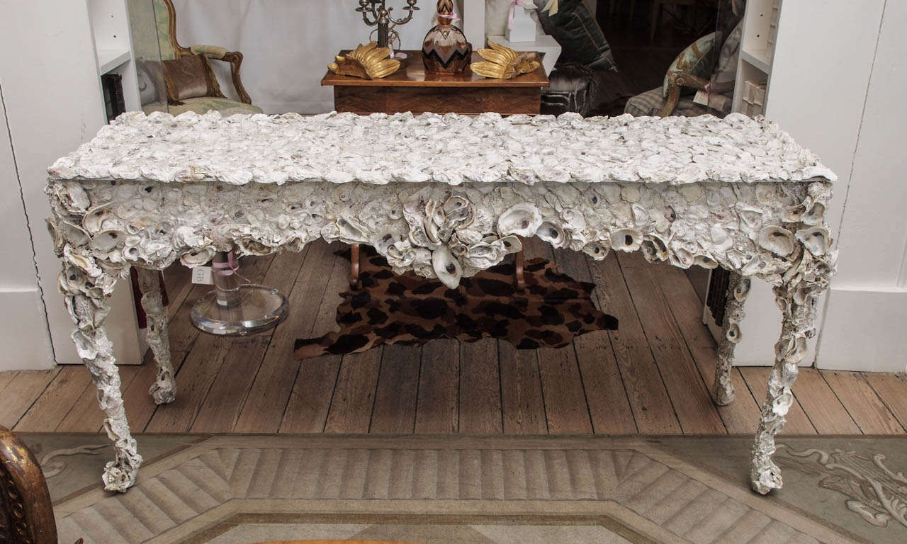 Console table with curving line made of oyster shells set in concrete.
