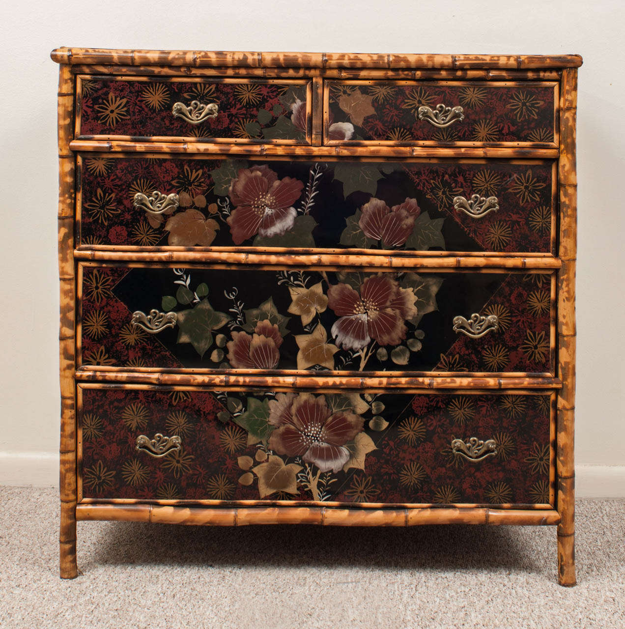 Fitted with two short and three long graduated drawers. Decorated through scattered floral sprays in an interesting design that continues across the drawers. Unusual and special piece.