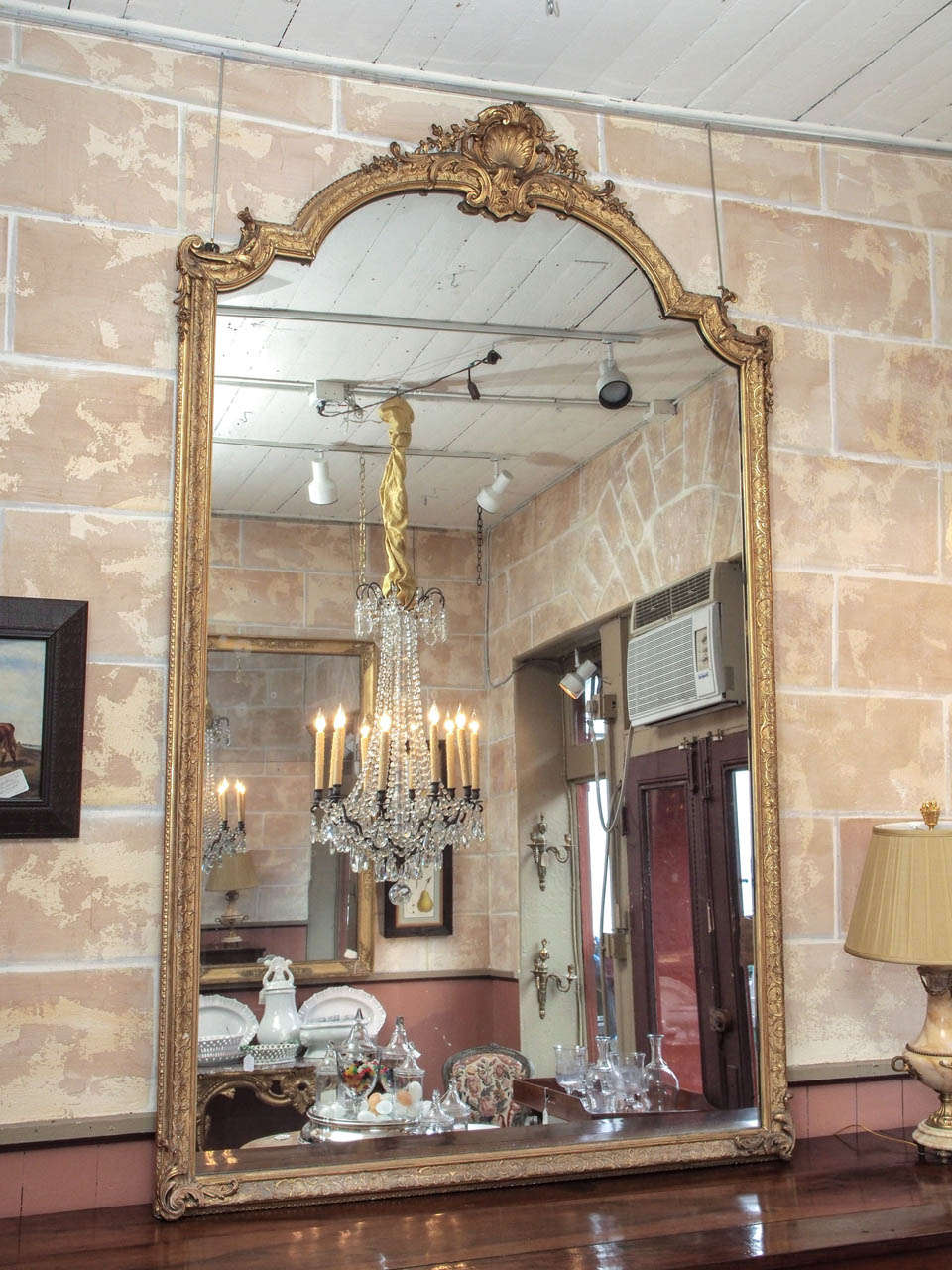 Grand French Napoleon III period carved and gilded mirror in the Regence taste, with shell ornament at crest.