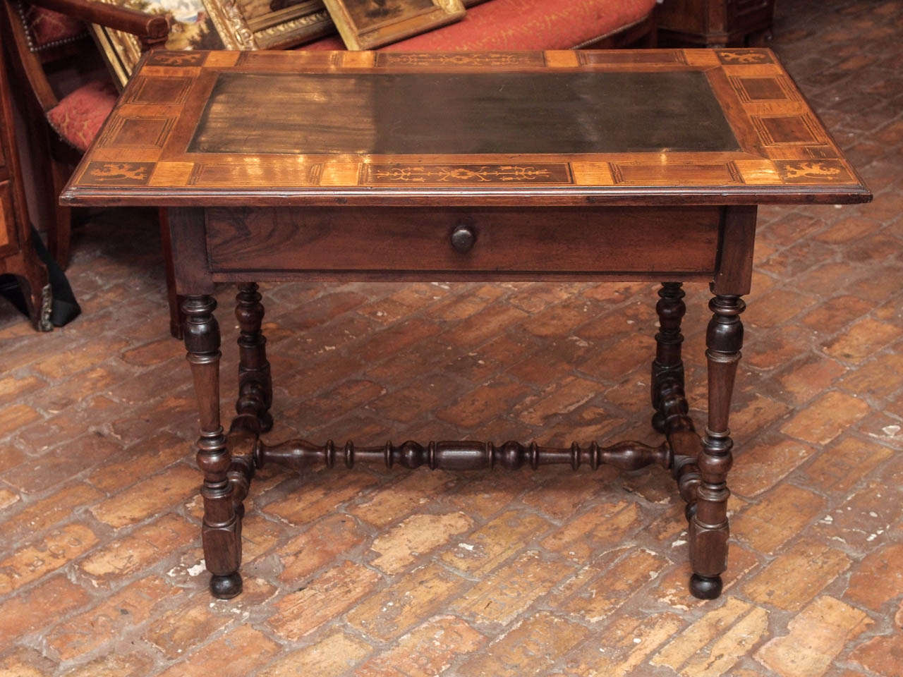 Late 17th century French marquetry table with lemon wood inlay, inset slate top, center drawer, and turned legs and stretcher, circa 1790.