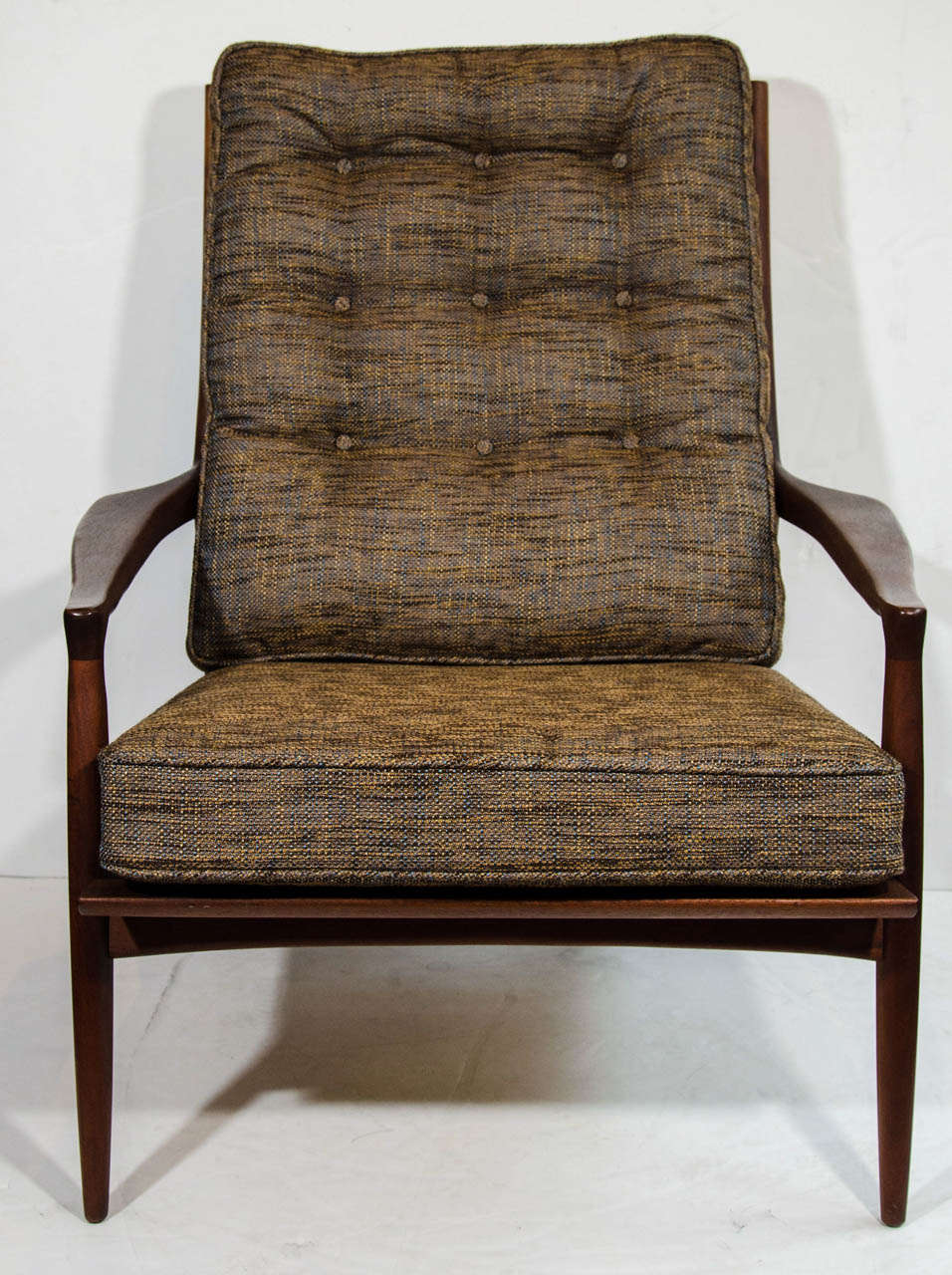 Outstanding easy chair with sculptural teakwood frame design. The chair features a reclined high back design with backside slat details, as well as super tailored lines. Has beautiful angular profile and carved stylized armrests. Newly upholstered