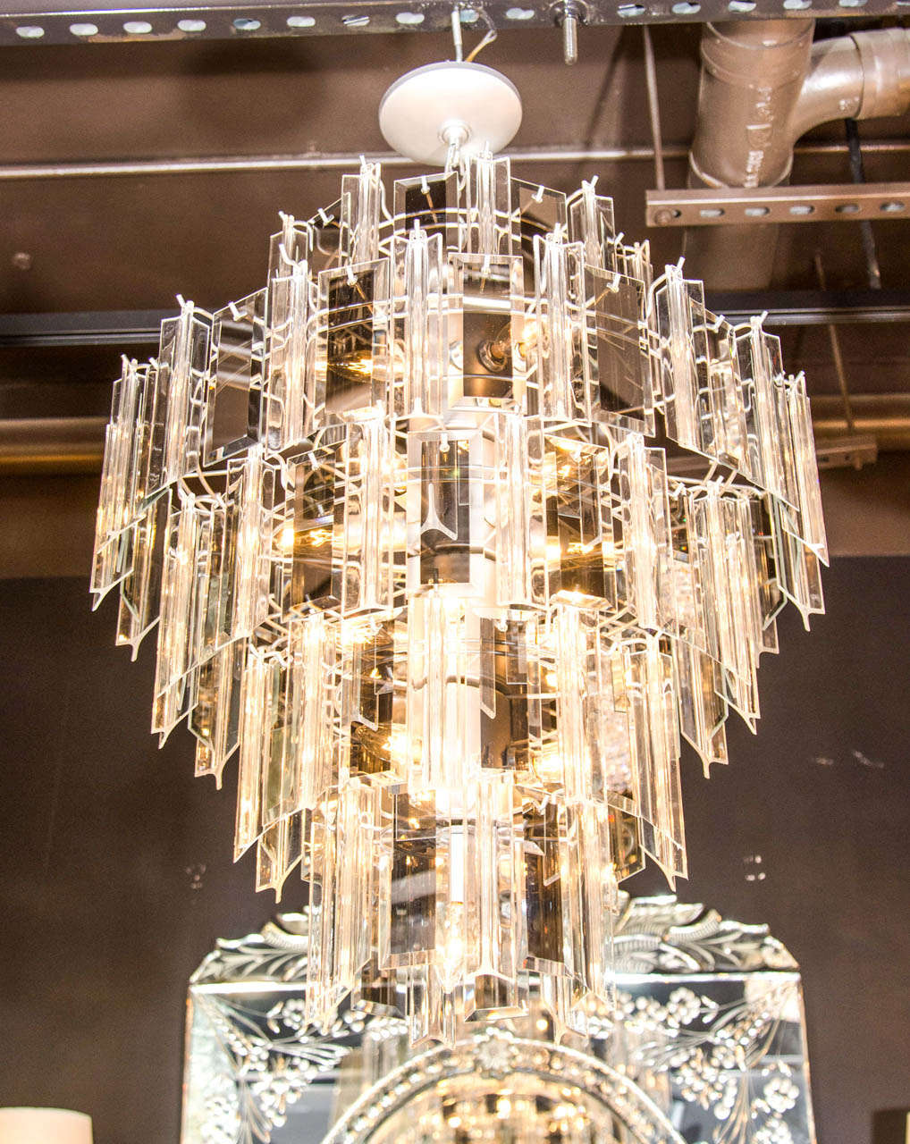 Modernist five tier chandelier with alternating glass panel prisms and lucite prisms. The glass prisms are rectangular in shape with hand beveled borders and have stunning smoked mirrored centers. The lucite prisms are fluted and three sided and