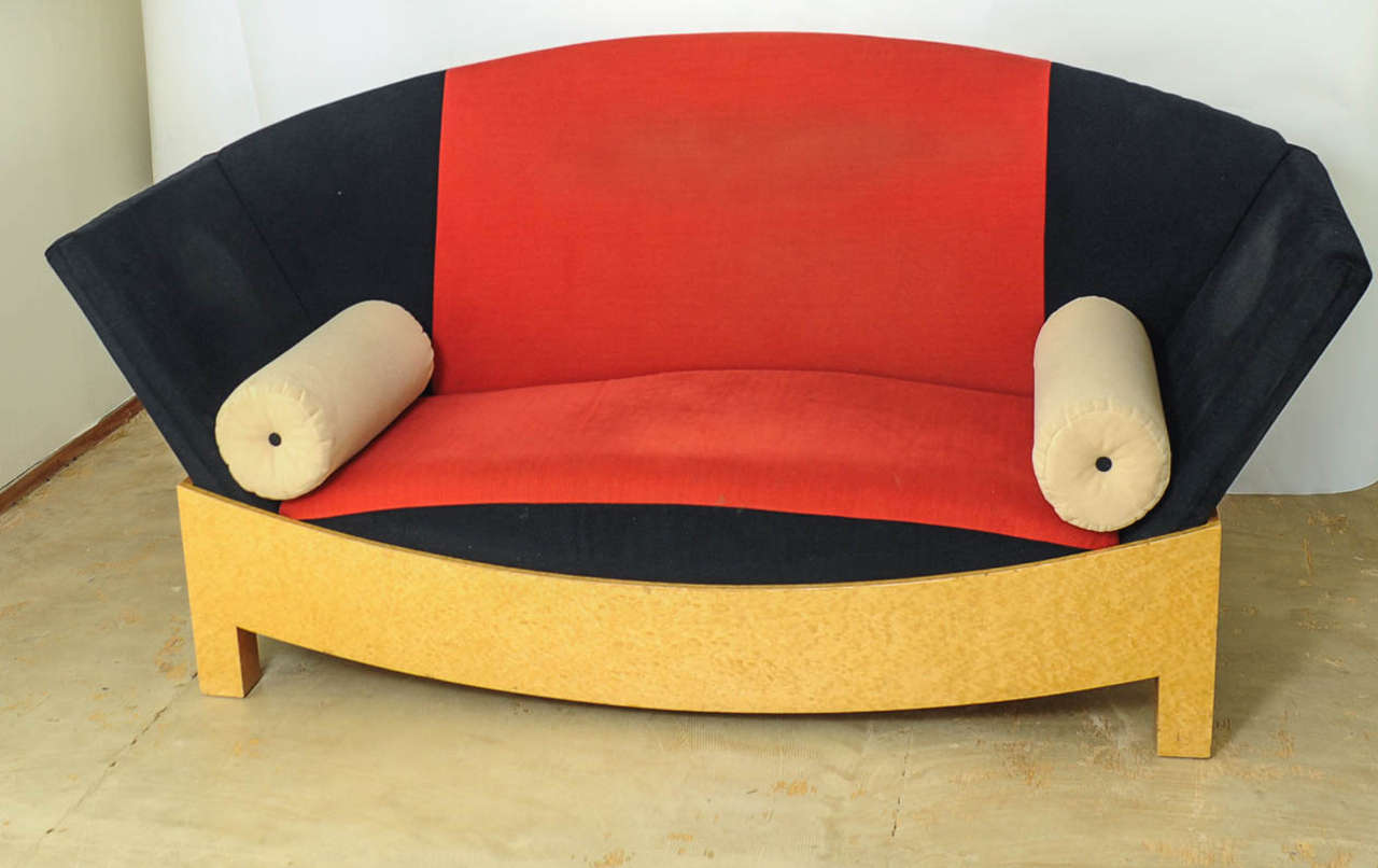Sofa made of a Wooden frame with veneer, polyurethane upholstery with textile cover in red, black and beige. 
The Austrian architect Hans Hollein (1934 - 2014) designed this sofa in Memphis style in 1981 for the Italian manufacturer Poltronova,