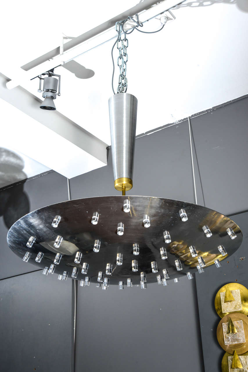 Suspension shaped like an UFO made of a two tones metal centerpiece and a large plate on which suspend many plexiglass pieces diffusing the light.