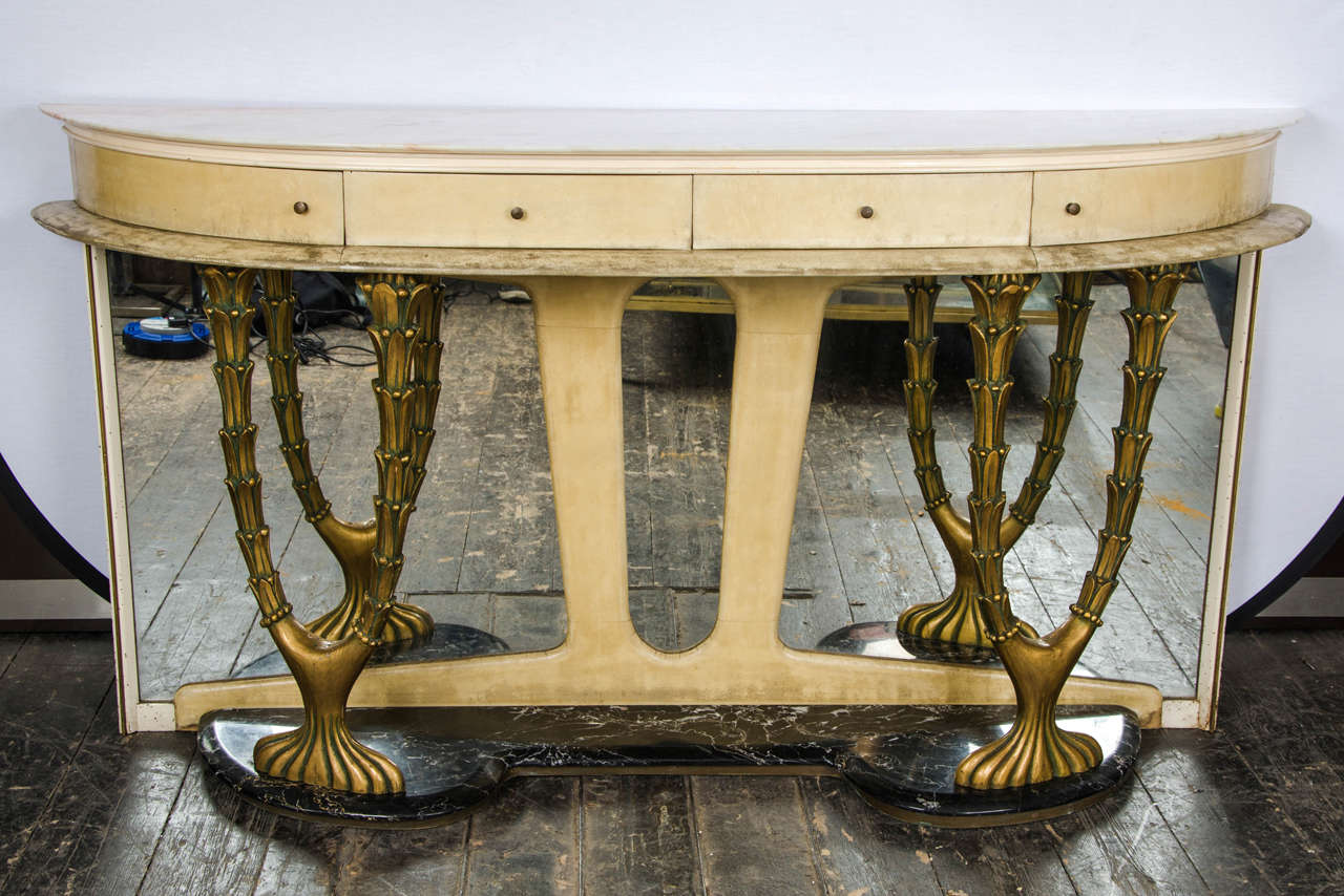 1940s Italian console table in parchment white marble top and dark marble base with decorative gild carved wood and attached mirror on the back with four drawers with decorative brass handles. By Dassi.