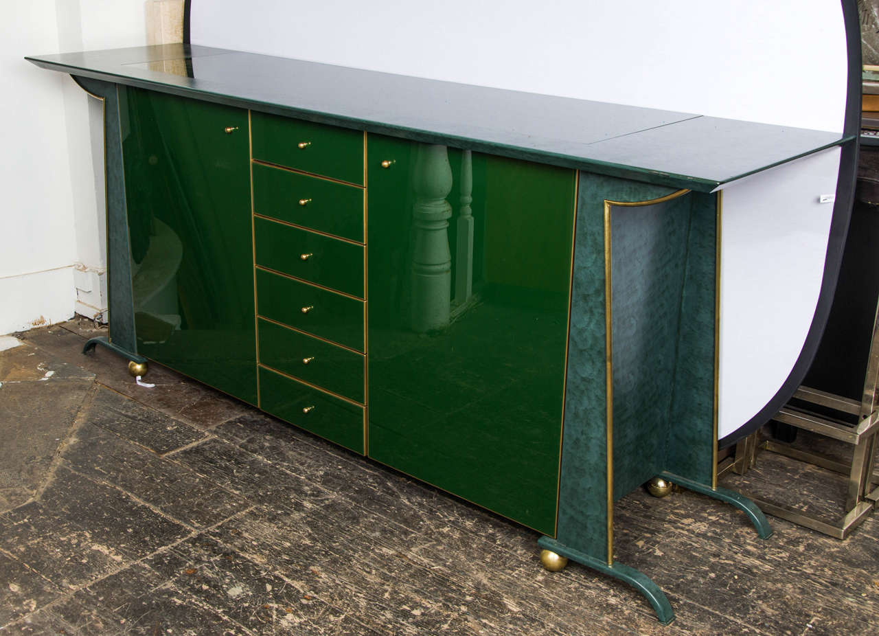 Stylish 1970s sideboard in antique polish metal, brass and green glass, with a drawers in the middle.