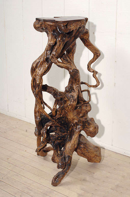 Vine root reticulated stand. Flat surface over gnarled and protruding stylized roots with a dark brown patina. A perfect piece of sculpture, stand or small table.