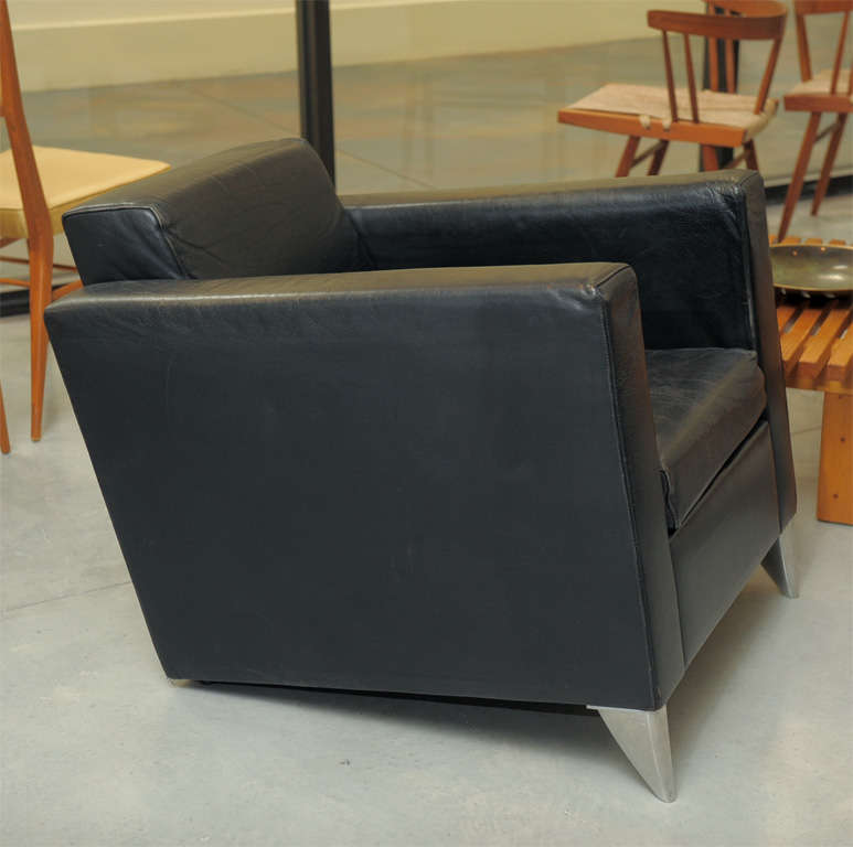 Philippe Starck, a pair of leather lounge chairs. Designed 1986, deep lounge chair, front features aluminium feet, embossed 'Starck', black leather covering, loose cushion. Four available.