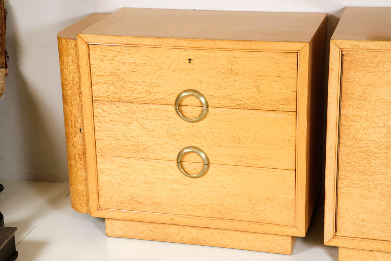 A suite of three Art Deco Cabinets in birds eye maple, the two end cabinets with three drawers and swing out compartment doors to the ends. The central cabinet with two doors, circa 1930s.
