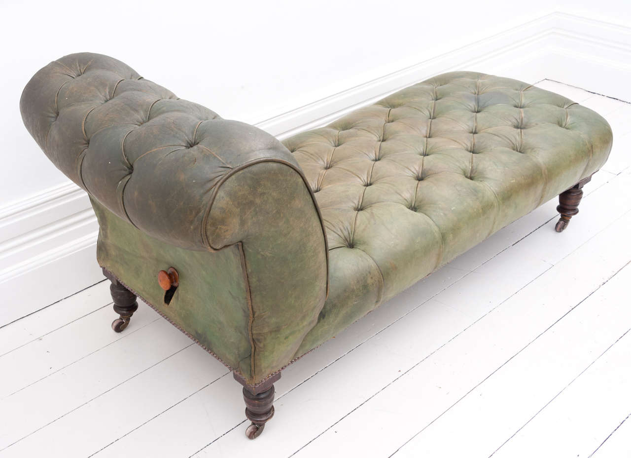 An attractive, Victorian, button-backed, green leathered, drop-end chaise longue, with original castors. The leather pull has been replaced at the back with a wooden knob, which when pressed releases the drop end very easily.