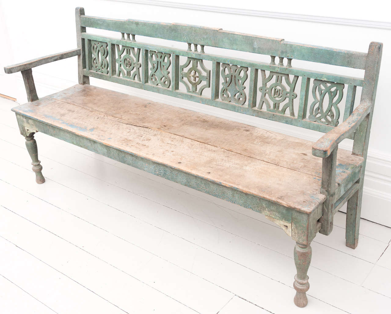 A very decorative and rare sycamore marriage settle bench, with the initials of a couple carved on either side in the back of the piece.  It retains its original blue, green paint and is highly stylised with its open carved back panels and overall