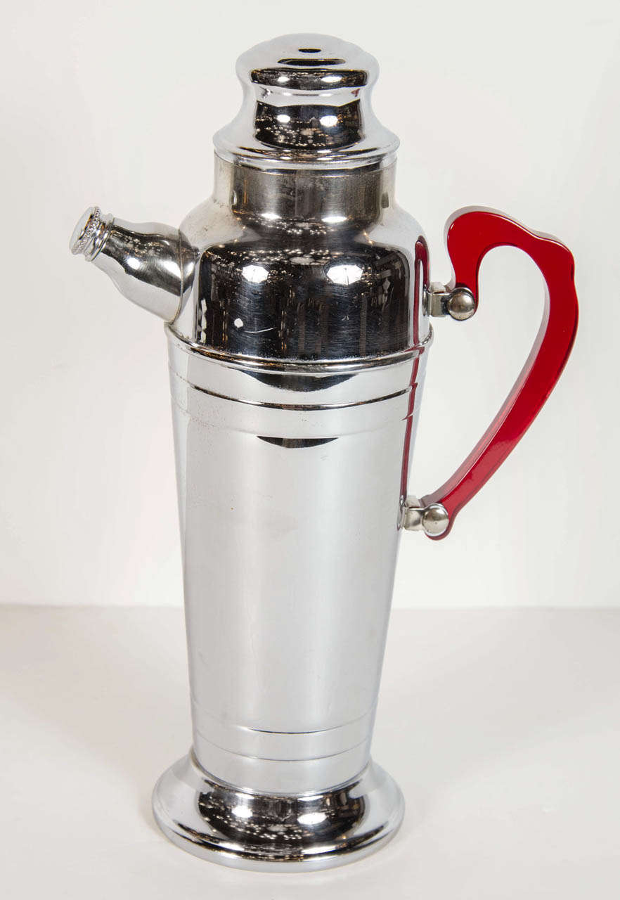 This gorgeous cocktail shaker is chrome with a red bakelite handle handle and epitomizes the machine ages influence on Art Deco in America.