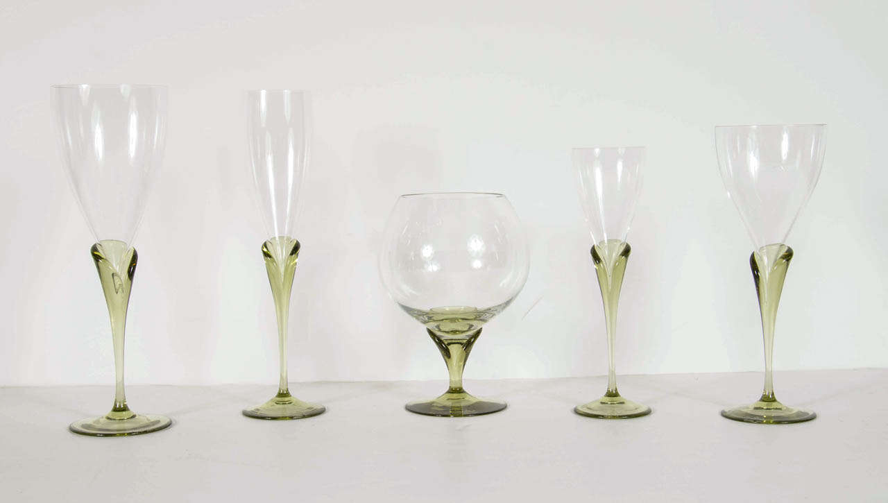 This stunning set features 12 Water glasses,12 white wine glasses,12 red wine glasses , 12 champagne flutes and 12 cognac/cordials glasses. This set features a stylized calla lily form stem in a beautiful peridot supporting a clear crystal