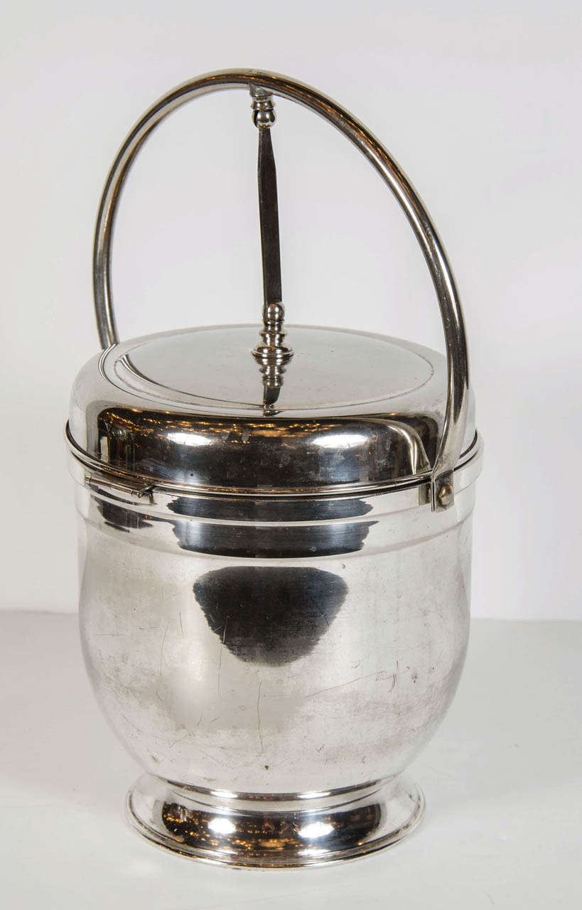 This unique Art Deco silver plated champagne bucket features a built in alternating flip-top lid which exposes an ice bucket when opened in one direction and bar accessories when opened in the opposite direction. In addition to it's innovative