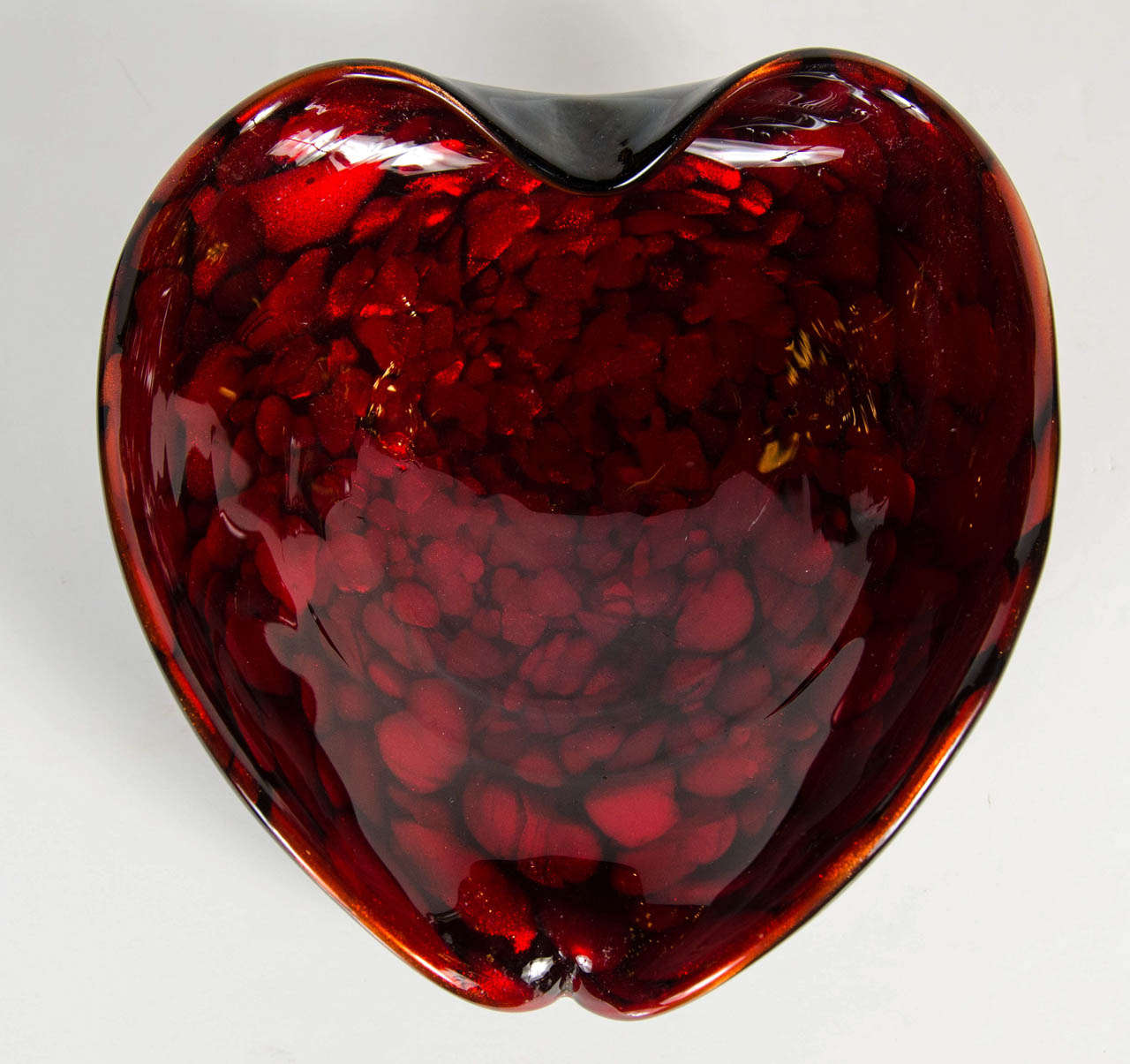 This gorgeous bowl features a stylized modernist form in shades of ruby on a black glass surround.