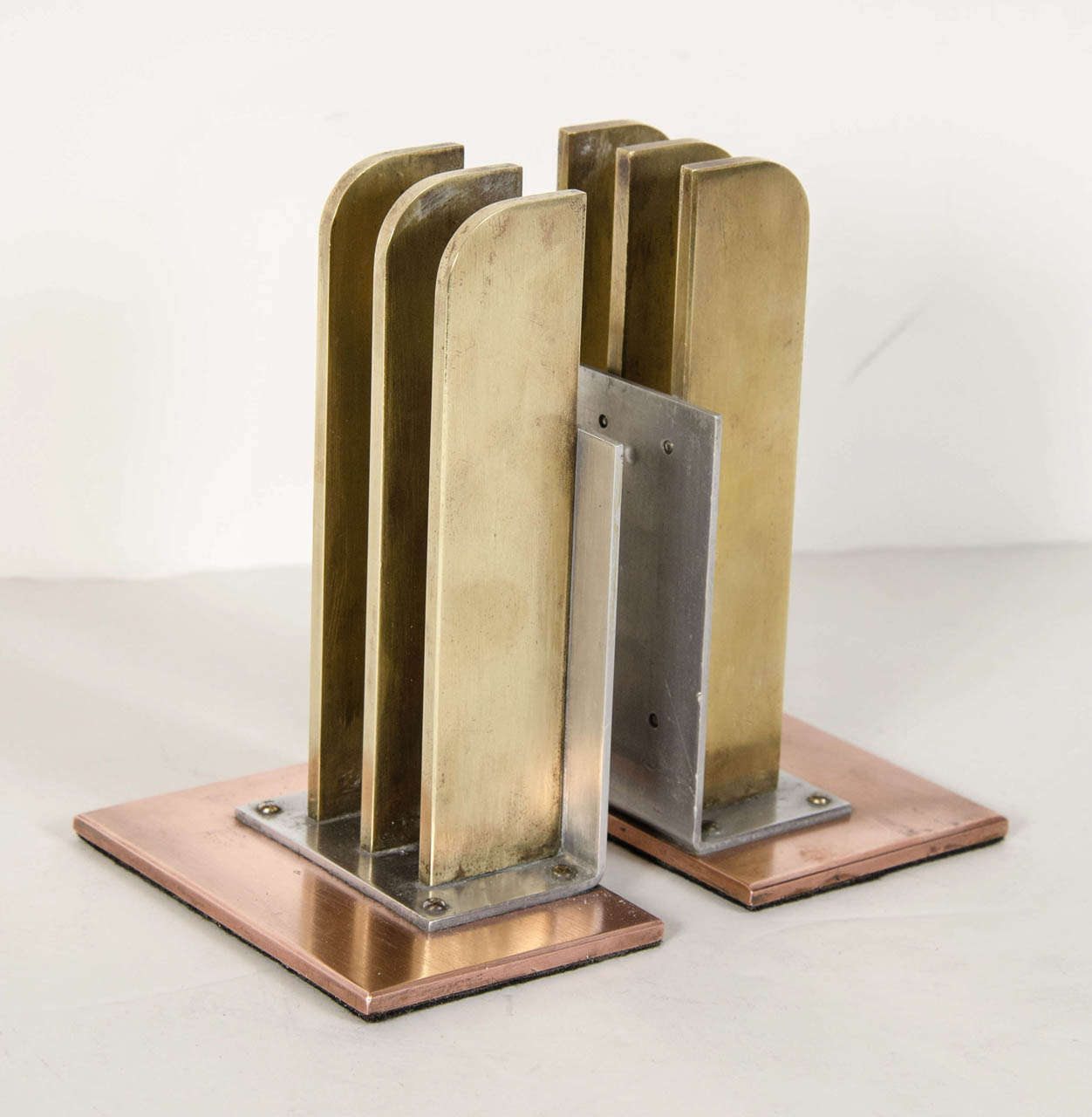 These exceptional pair of bookends exemplify the Machine Age movements influence on Art Deco in America . They are made of brass ,copper and polished aluminum .