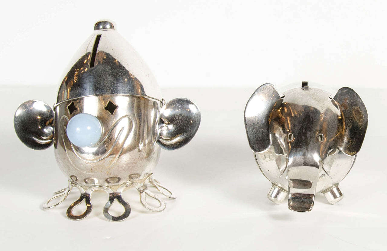 These gorgeous silver-plate banks by the Napier Co feature a stylized clown with a pale blue bakelite nose.The elephant features a stylized scrolling trunk and tusk details.They both are a great streamline Art Deco modernist design.Can be sold