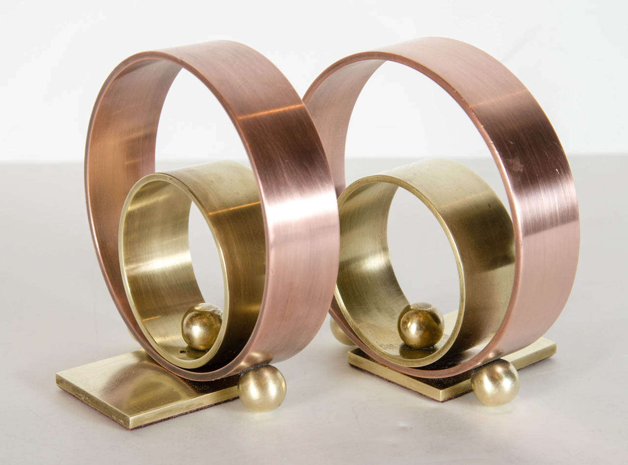 These Art Deco bookends by Walter Von Nessen feature two concentric rings of brass and copper with three sphere accents on each. These bookends really exemplify the Machine Ages influence on Art Deco in America.