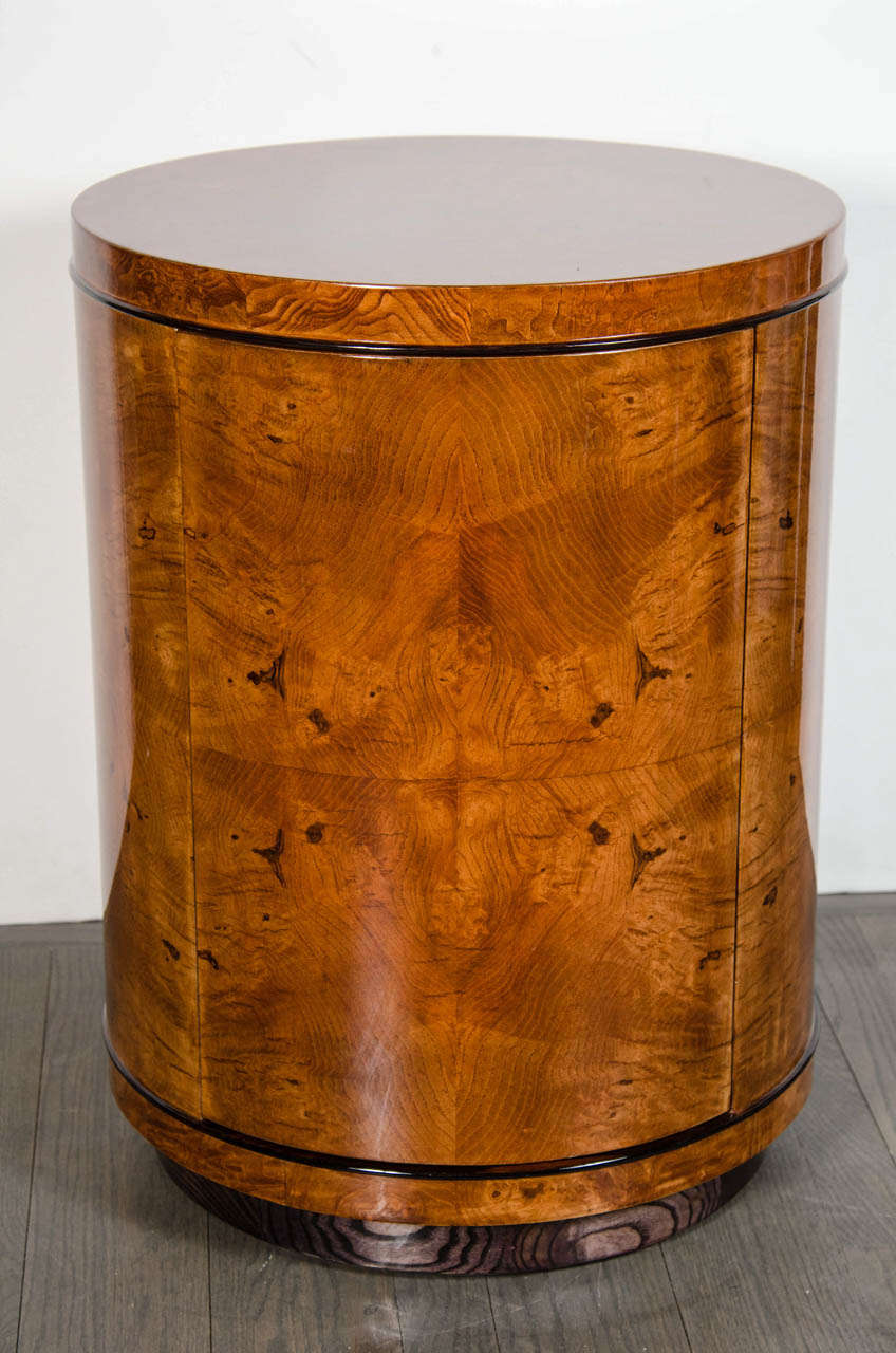 Art Deco drum style occasional table in stunning book-matched exotic burled Carpathian Elm with black lacquer detailing around the top and bottom portion which frames the Carpathian Elm perfectly.  The table sits atop a black lacquer drum base. 