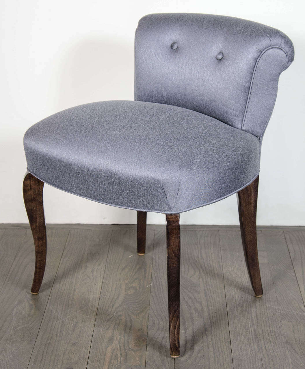 1940's Hollywood vanity chair upholstered in a chic platinum / blue sharkskin.  It has a scroll back design with two button back detailing and ebonized walnut cabriole legs that mimic the silhouette of the scroll back design.  It has been newly