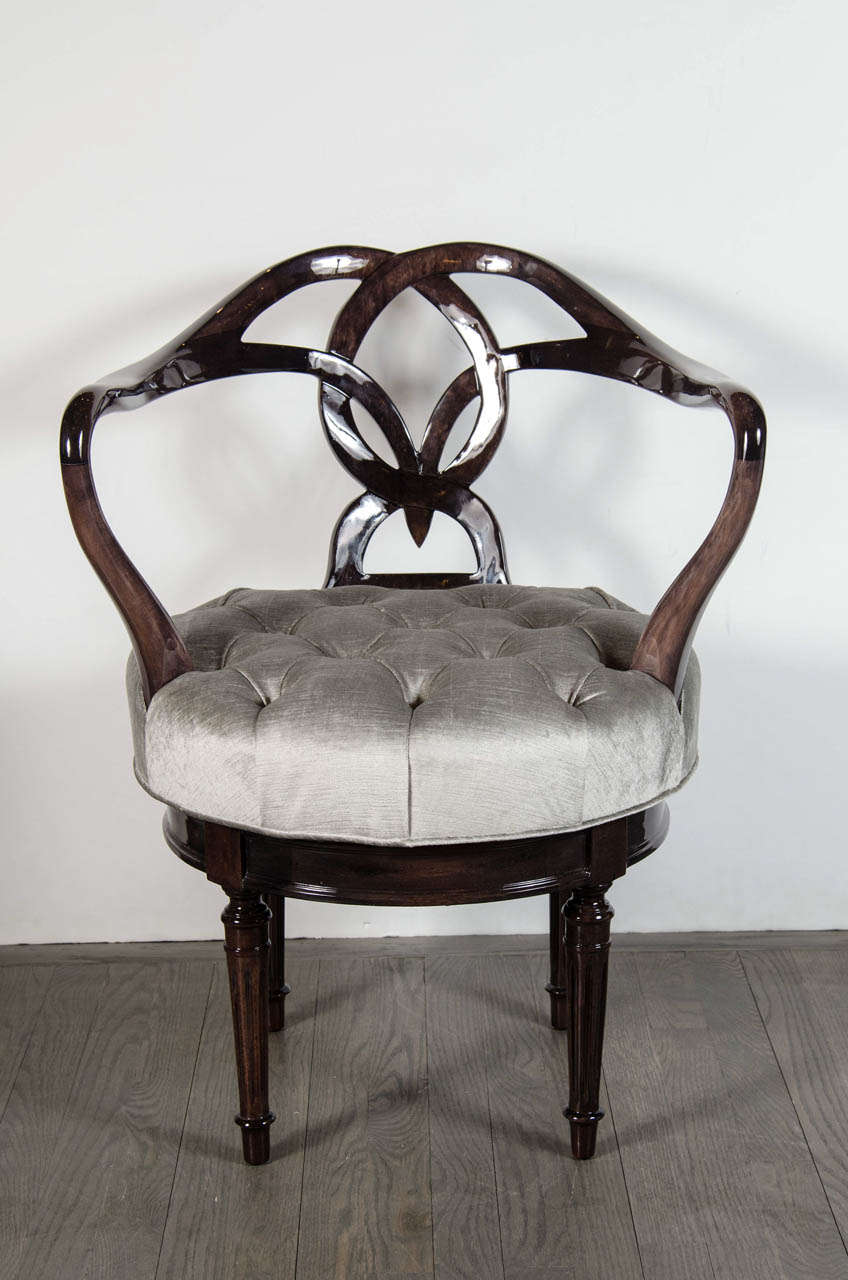 This very unique Mid-Century Modernist swivel chair features ebonized walnut in a woven knot design and tufted platinum velvet upholstery. The chair has been newly restored and reupholstered.