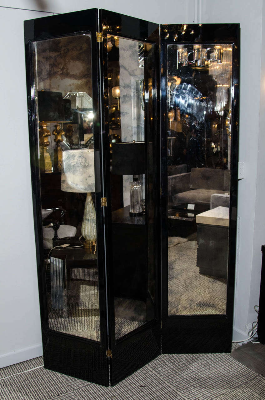 This elegant 1940's Hollywood tri-fold screen features ebonized walnut and antique smoked mirror inset panels. It is in restored mint condition.