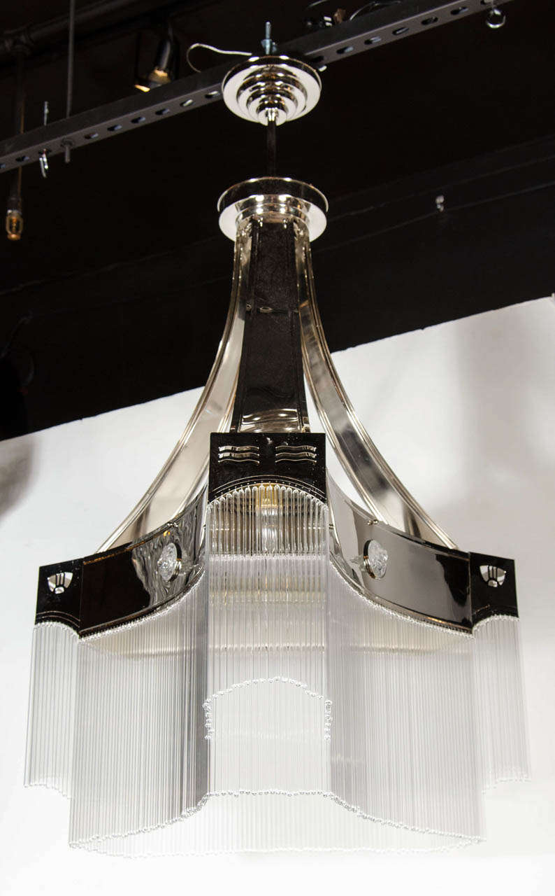 Spectacular French Art Deco style chandelier in the manner of Joseph Hoffmann. This chandelier starts at the top with a four stepped designed canopy then leads to the to three streamlined arms that hold the chandelier body. These banded arms start