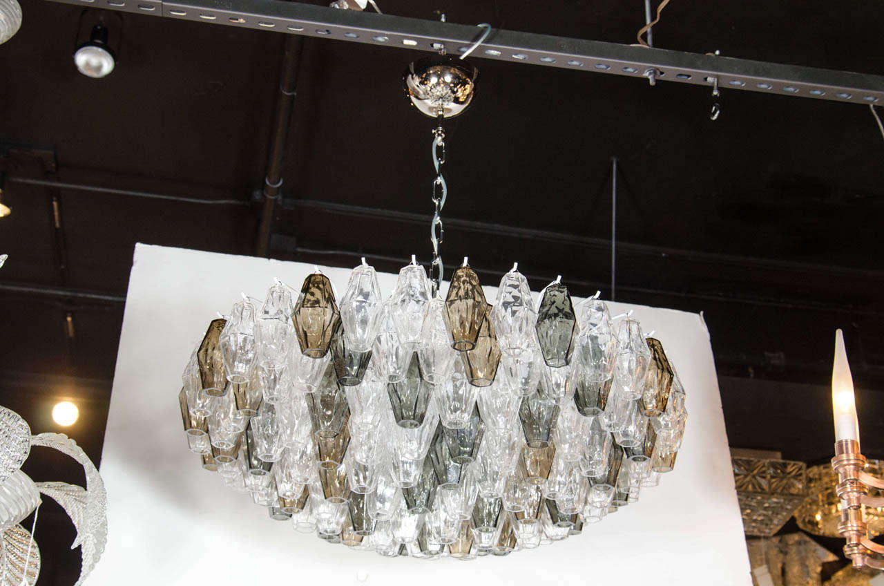 This pair of spectacular Murano glass chandeliers by Venini features numerous hand blown Murano glass polyhedral shades in a beautiful array of smoked, gray and clear glass. Each glass polyhedral shade is individually hung from its frame by hand.
