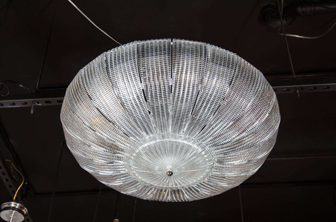 An exquisite flush mount chandelier was realized in Murano, Italy- the island off the coast of Venice renowned for centuries for its superlative glass production. It features an abundance of sinuously curved leaf like shades handblown in translucent
