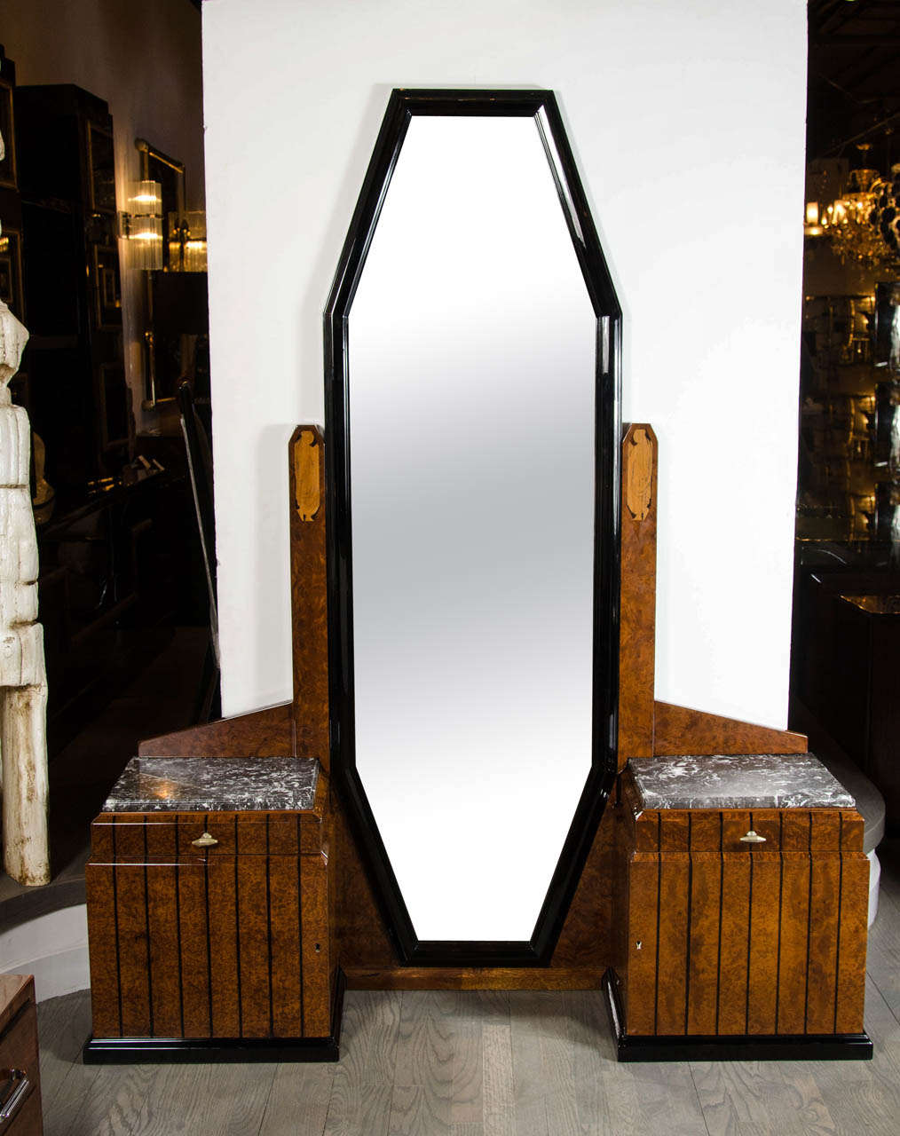 This elegant Art Deco floor-standing vanity or dressing mirror in book-matched burled elm features strong skyscraper Art Deco cubist geometric details, a full length octagonal mirror flanked by two exotic marble-top cabinets, each fitted with a