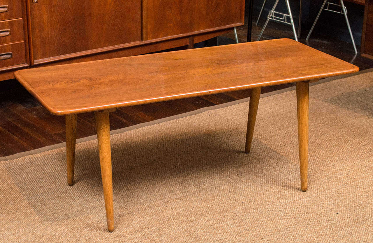 Hans Wegner deign coffee table for Andreas Tuck, Denmark. Having a sculpted teak lip top on oak legs and supports, perfectly refinished and stamped.