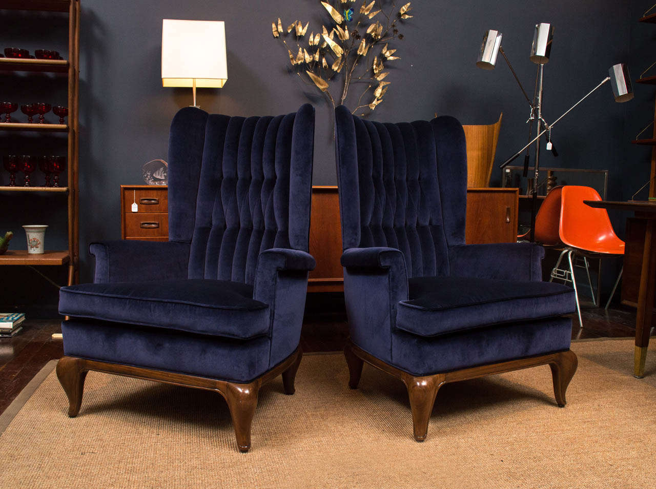 Maurice Bailey design wing chairs for Monteverde-Young. Bold carved mahogany bull horn form base with classical diamond tuck midnight blue velvet upholestry. Perfectly refinished and upholstered.