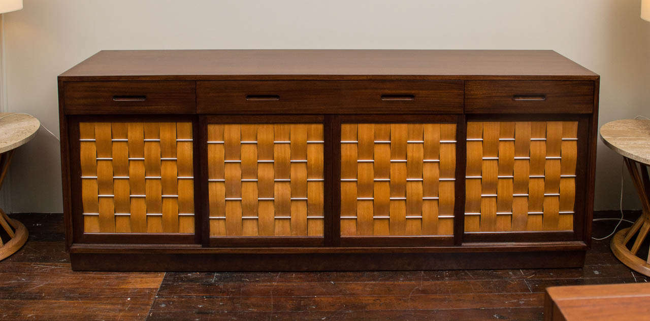 Edward Wormley design for Dunbar mahogany credenza, four sliding woven front doors with fitted interior drawers and shelves. 
Completely refinished and labeled.