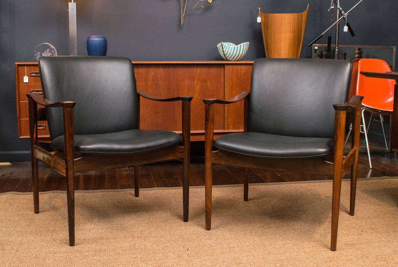 Elegant and refined pair of Danish solid rosewood armchairs designed by Frederik Kayser Model 711. Perfectly restored and upholstered in new black leather.
