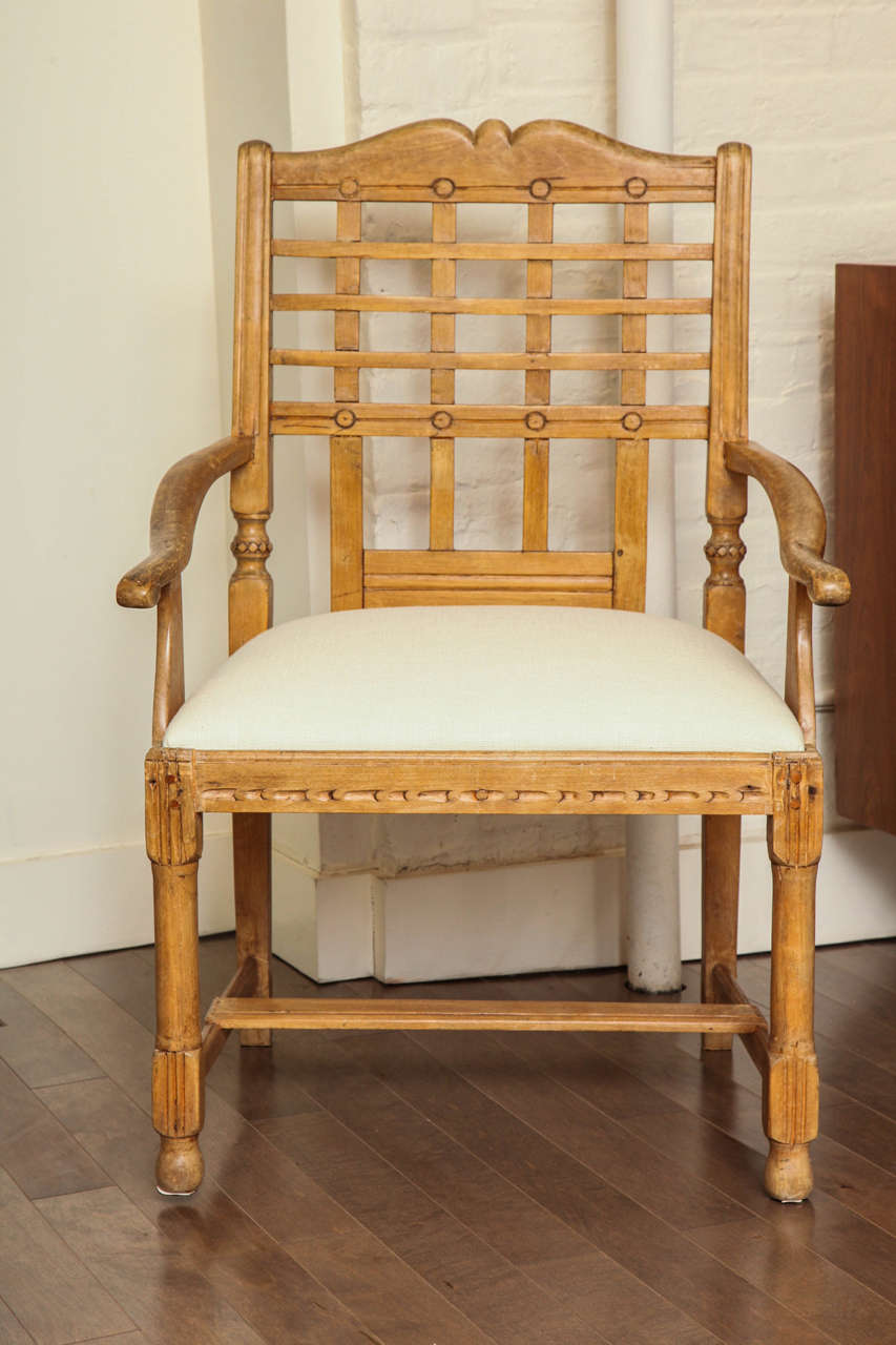Pair of carved Primitive armchairs with natural wood and newly upholstered ivory linen seat, India, circa 1950.