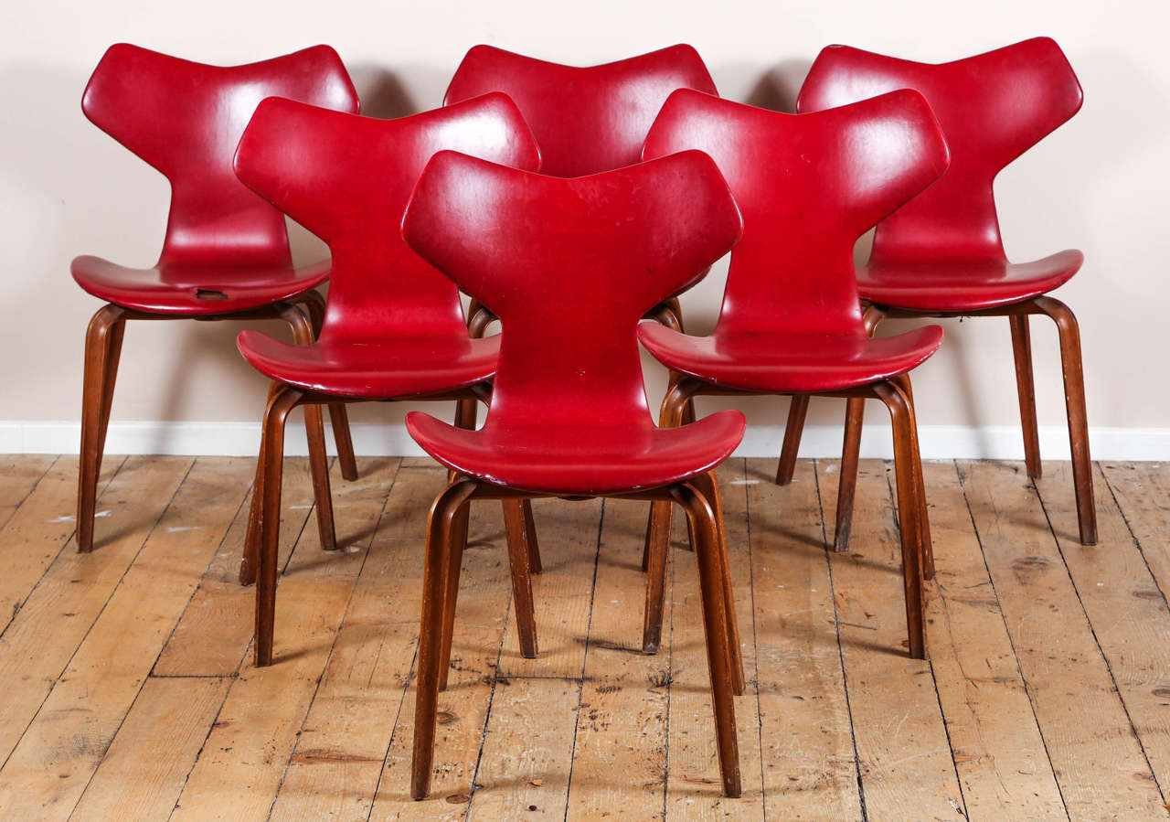 Early set of four teak and vinyl Grand Prix chairs by Arne Jacobsen for Fritz Hansen. Made in Denmark circa 1950s.

These are an example of earliest version because of the wooden legs which are no longer in production.