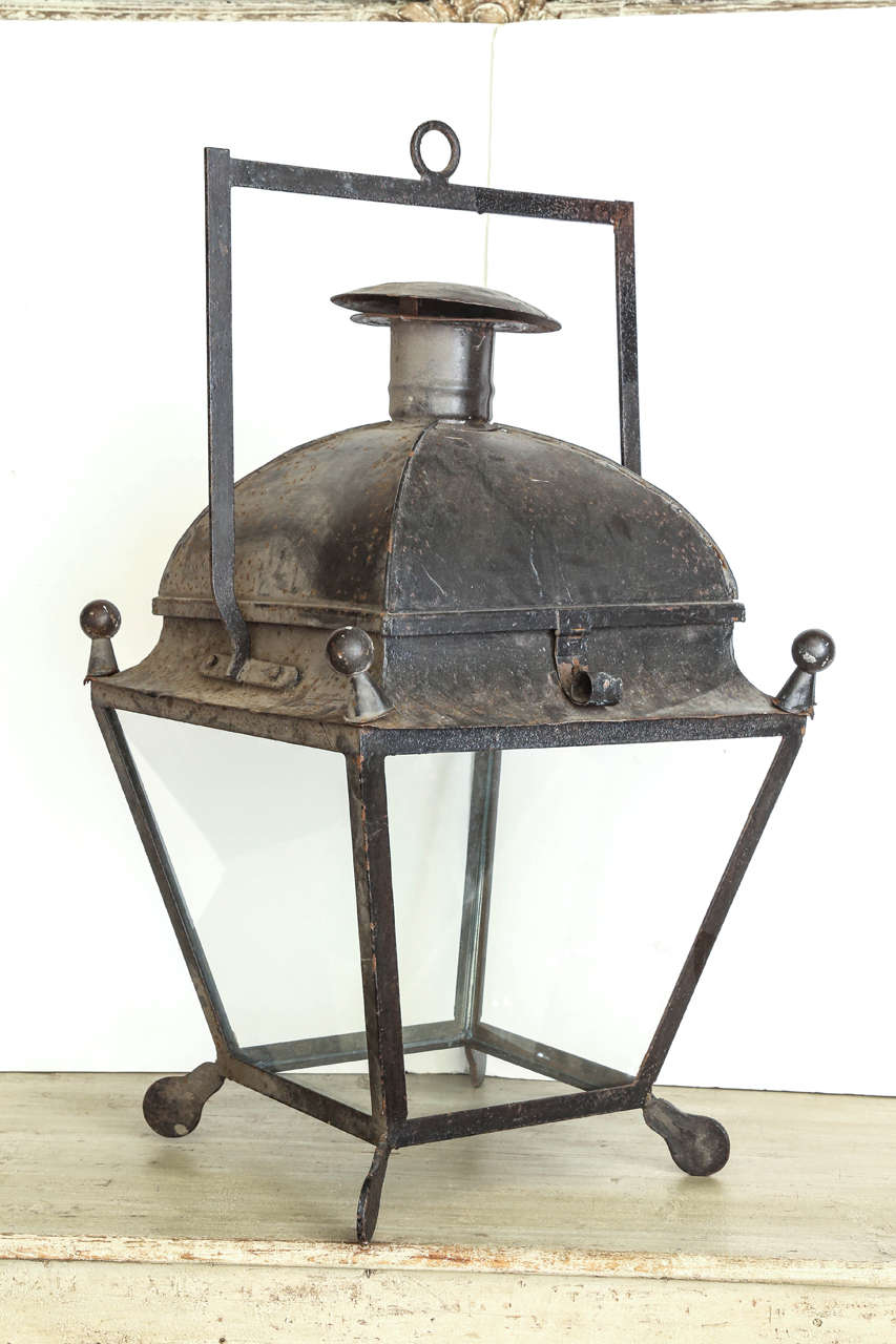 Tole and iron stable lantern from Provence. Has a hinged lid for access with four finials and four feet. Glass has been replaced. Two lanterns available @4800. each.
