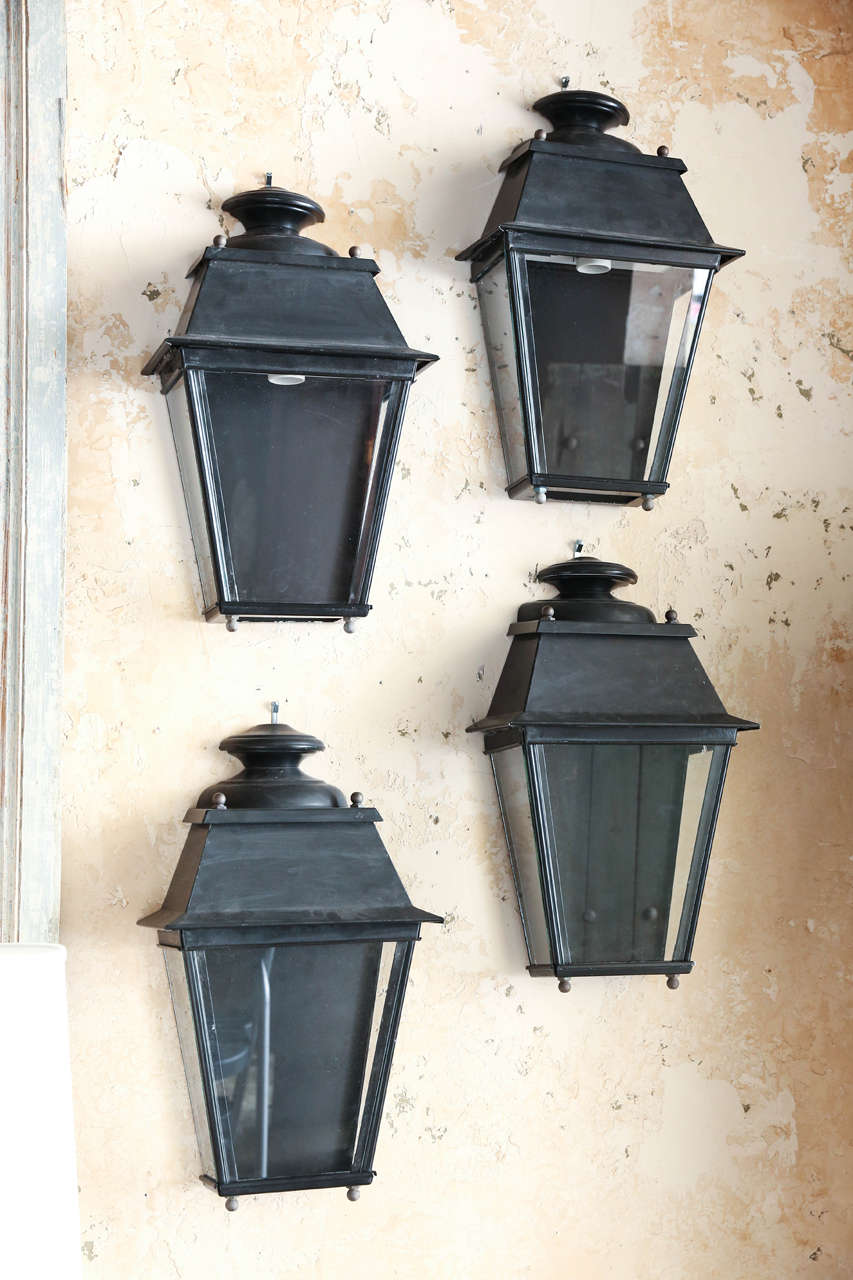 Pair of French tole lanterns in black with brass finials.