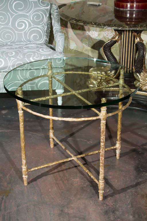A round gold leafed wrought iron side table. Wrought iron has gesso applied to the outside for a rough forged look in the style of Giacometti. Then gold leaf was applied to the gesso.