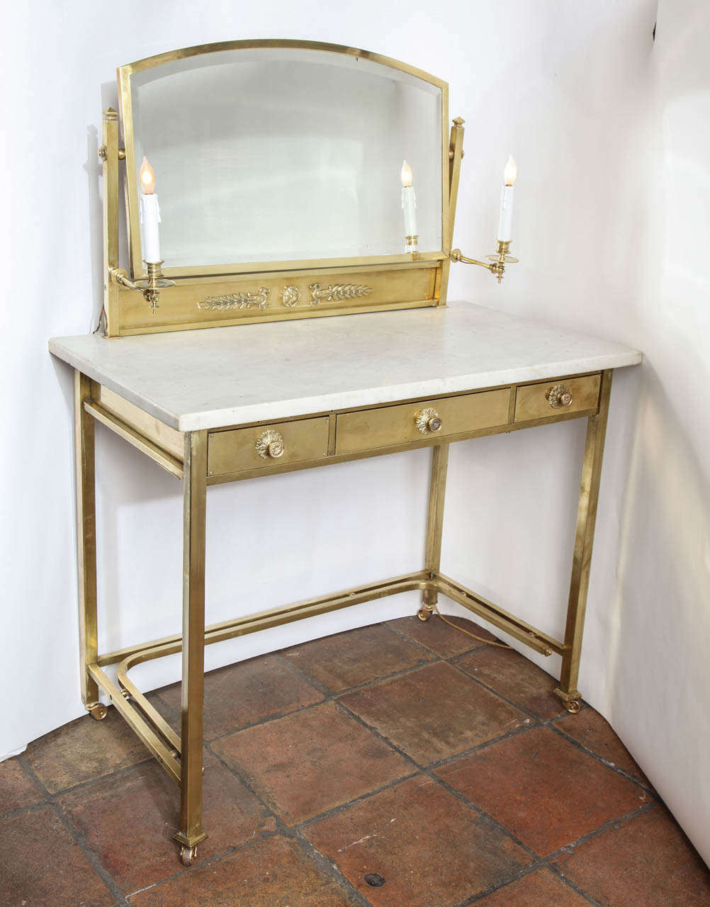 A elegant and timeless Masion Jansen white marble top vanity in brass with three drawers and a swivel mirror (19.5