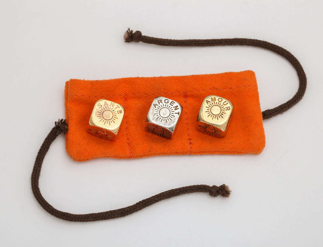A entertaining set of weather dice showing the results of money health and love. With orange Hermes felt holding pouch in plated gold and silver