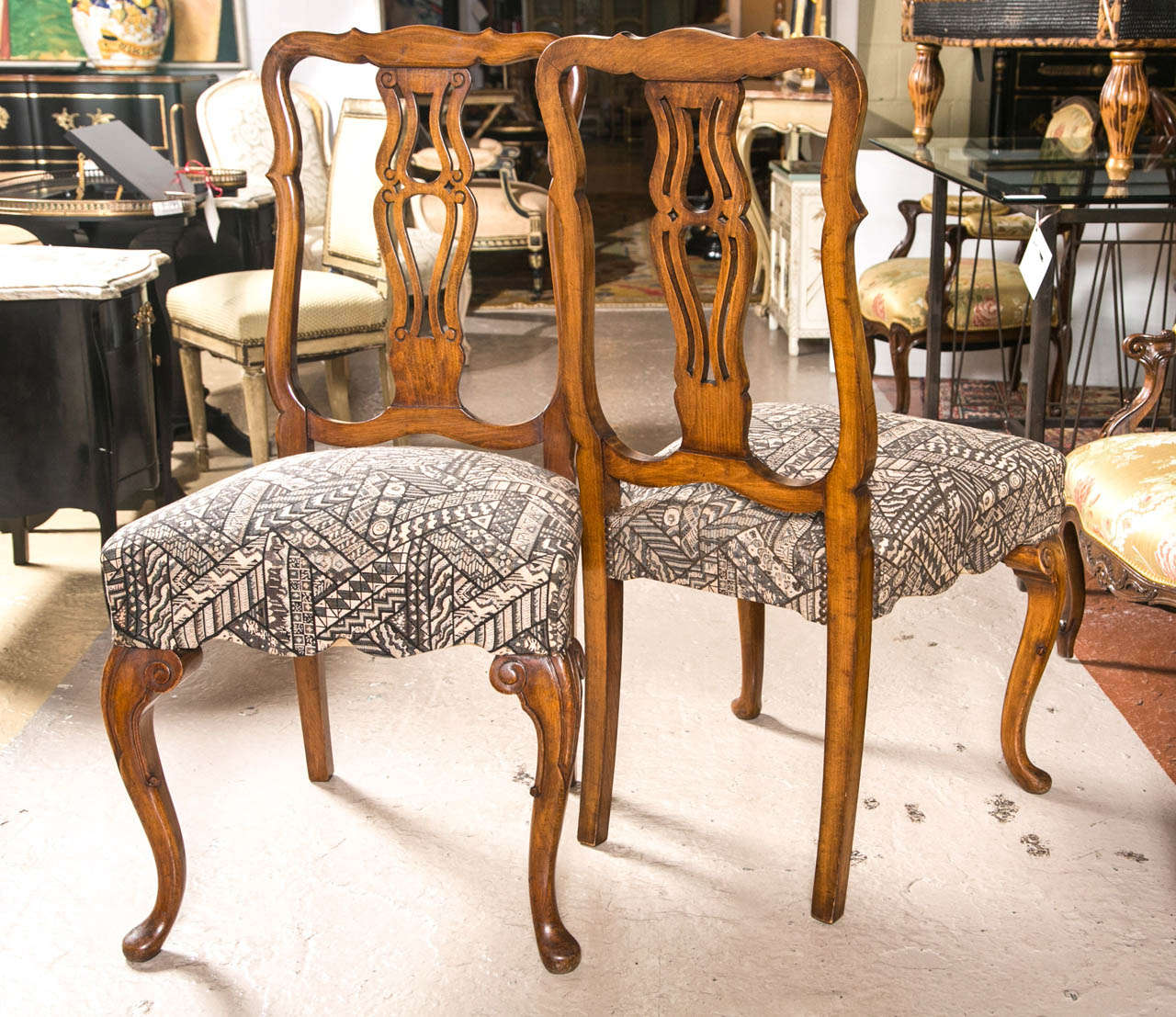 Set of ten Queen Anne styled dining chairs. A fine set of ten dining chairs in new fabric each with a walnut curved Queen Anne cabriole leg. The wooden back splash having a double figure eight design. Can buy as little as six or all ten.