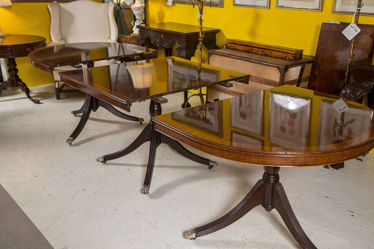 20th Century An English Georgian Style Triple Pedestal Banded Mahogany Dining Table