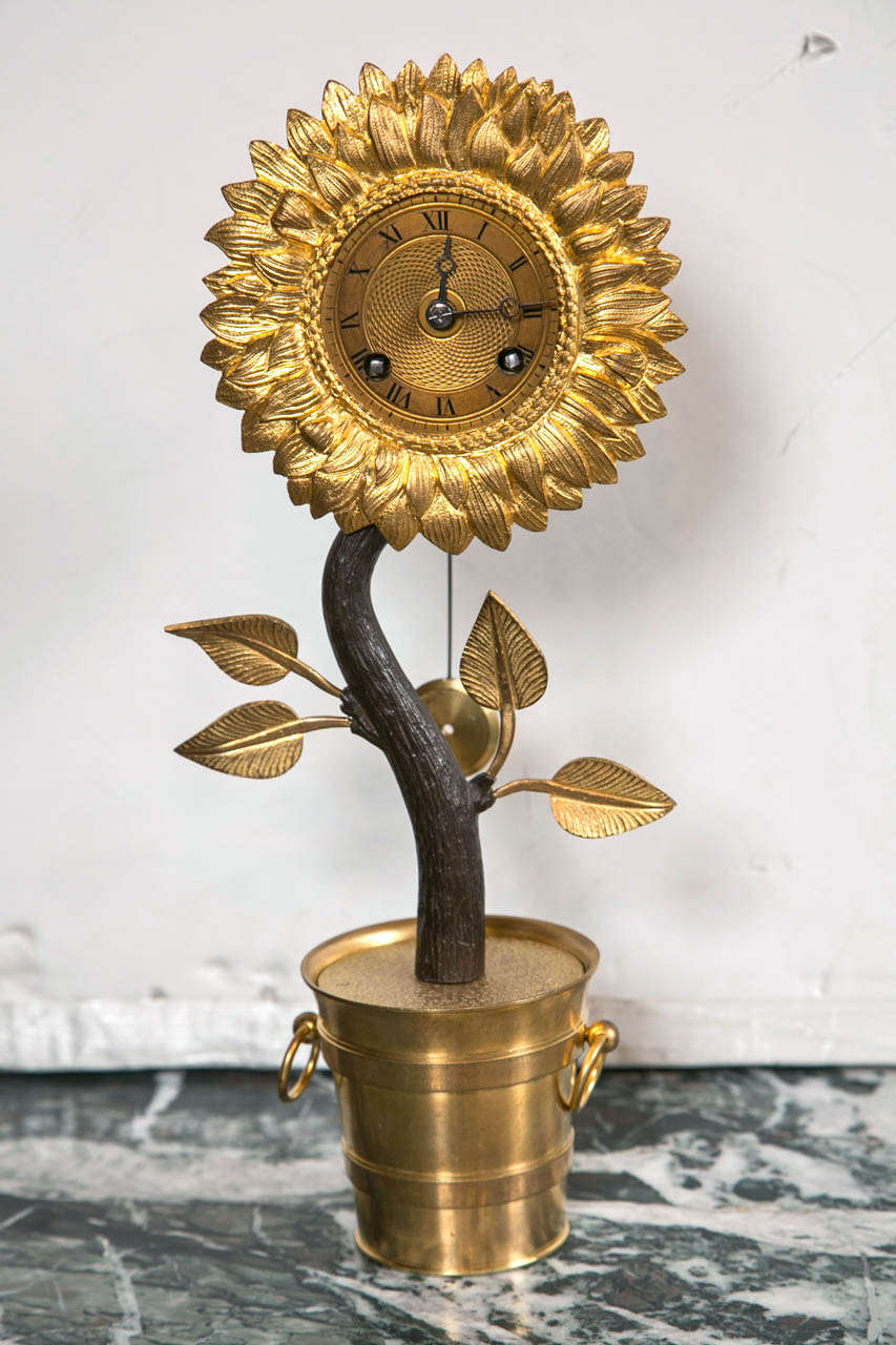 A bronze silk thread, sunflower form clock with half hour strike on bell.