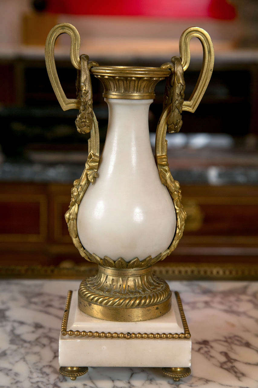 A pair of French white marble and ormolu urns in Louis XVI style.