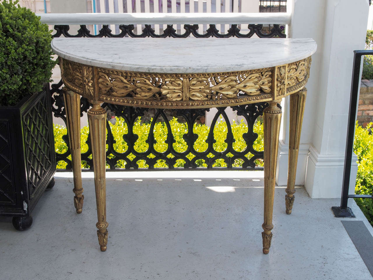 Louis XVI Gilt Wood pierced apron demi lune console table with carrera marble top. The frieze having acanthus motif with reeded legs and lambs tongue borders.