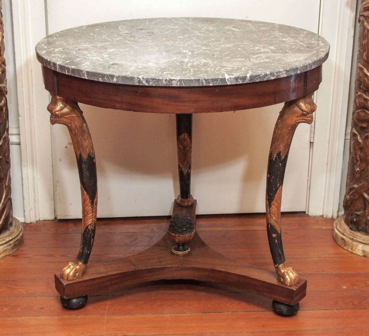 French Empire Marble Top Gueridon with monopodial eagles in patinated paint and gilt with a artichoke finial in the center.